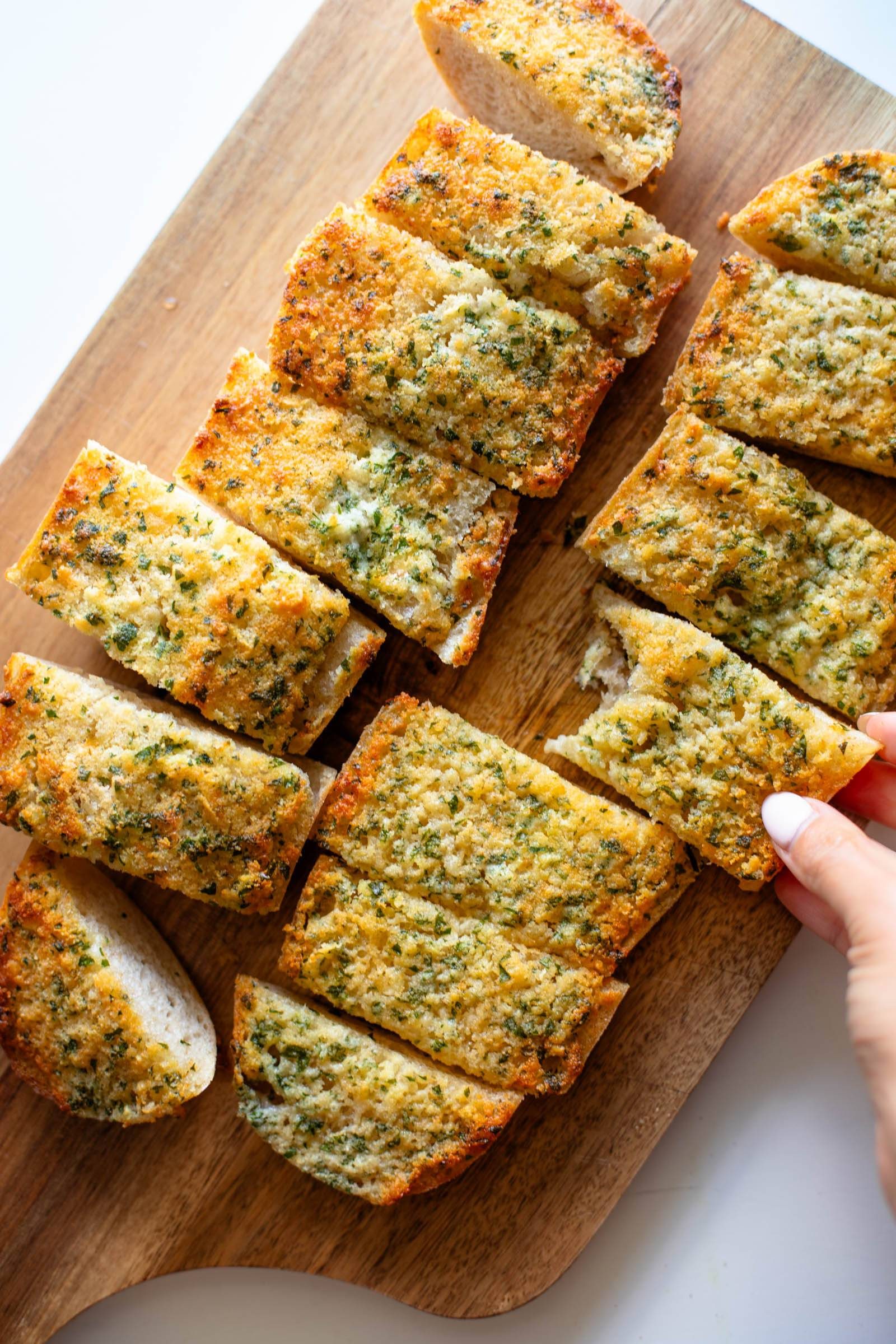 Garlic bread sliced on a cutting board.