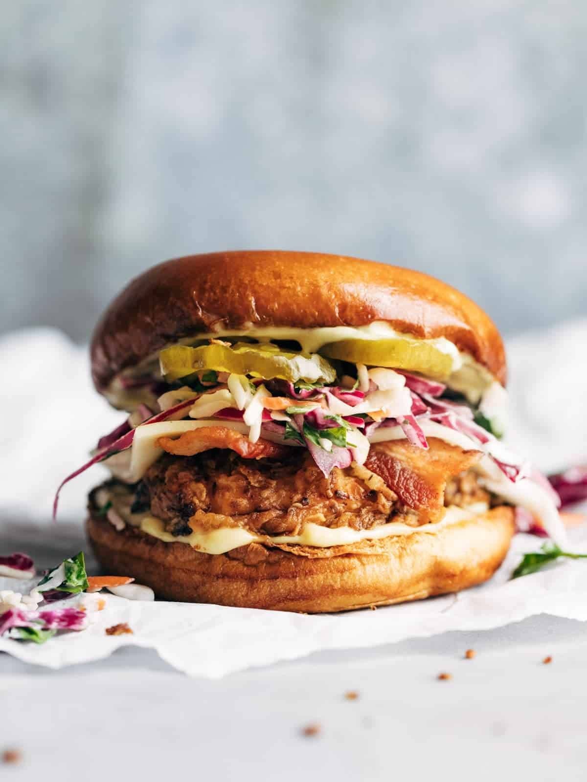 Fried chicken sandwich topped with slaw and pickles.