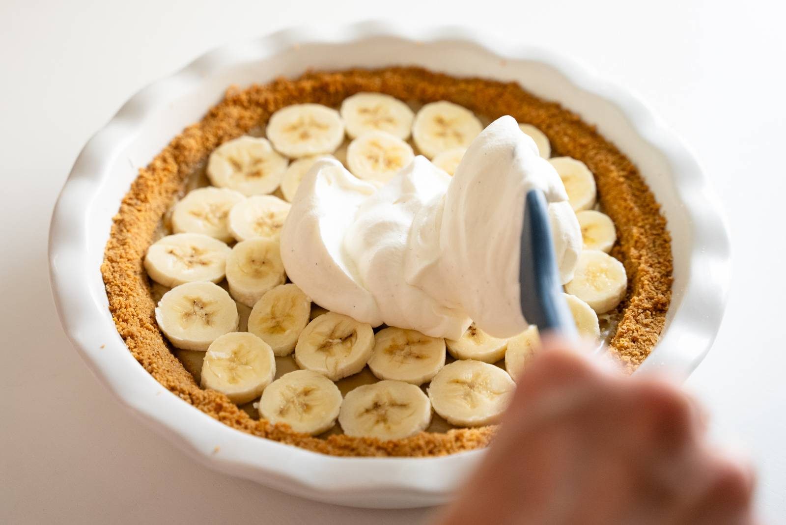 Adding bananas and whipped cream.