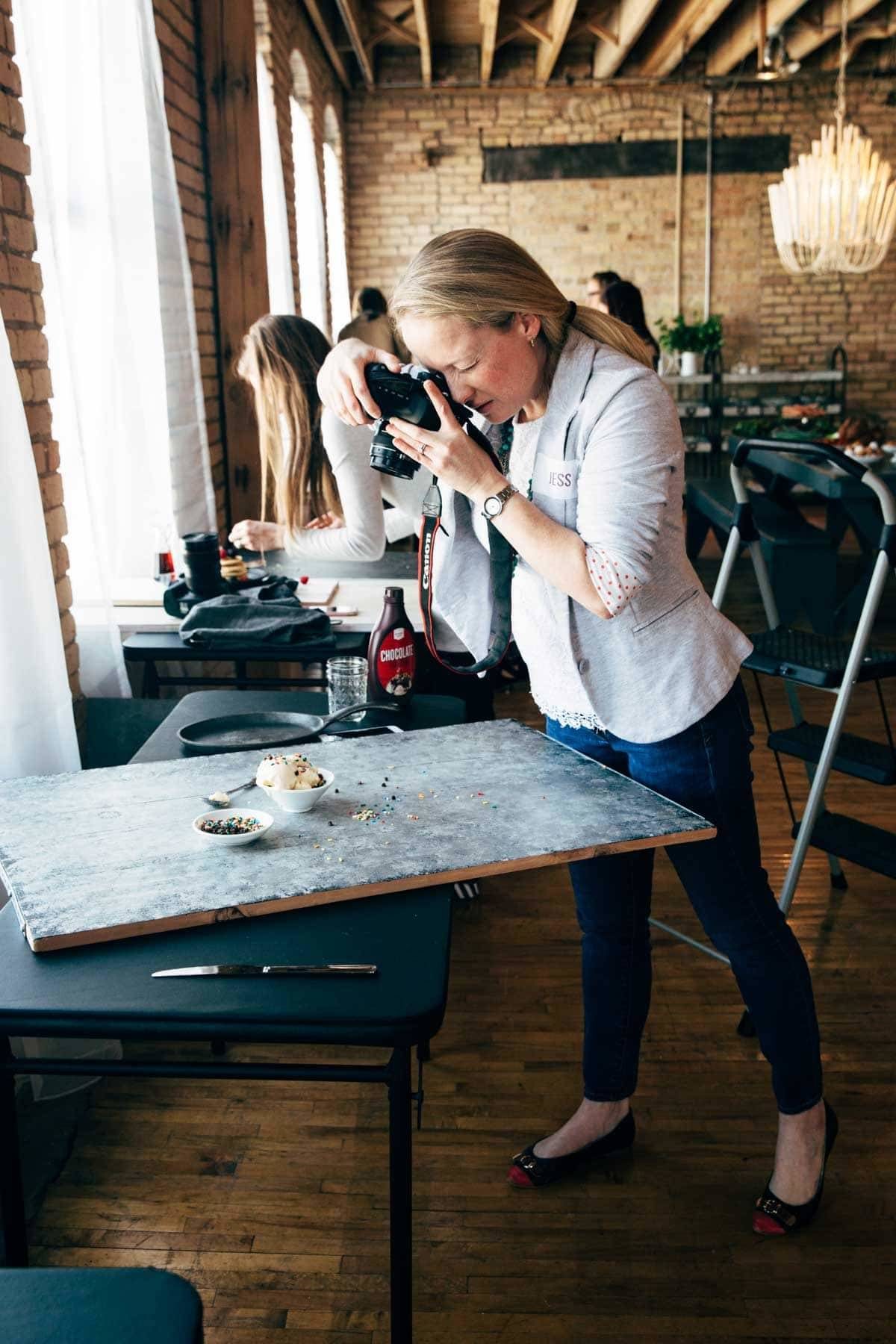 Woman with a camera photographing food.