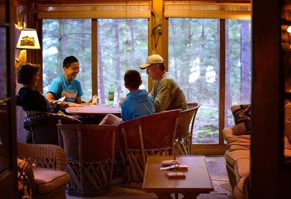 Family members playing cards in the dinning table.