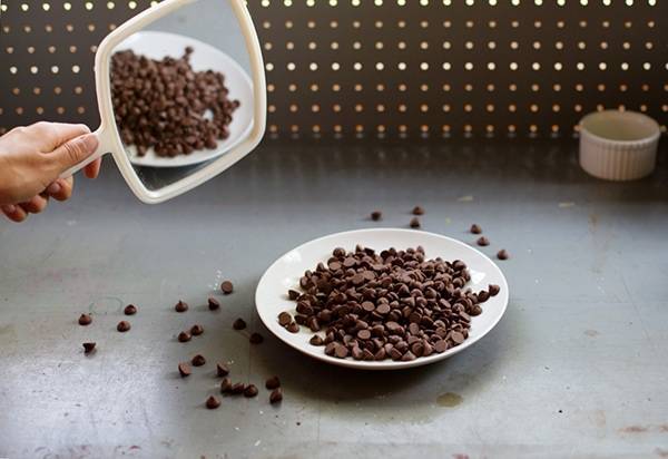 Hand mirror above a plate of chocolate chips.