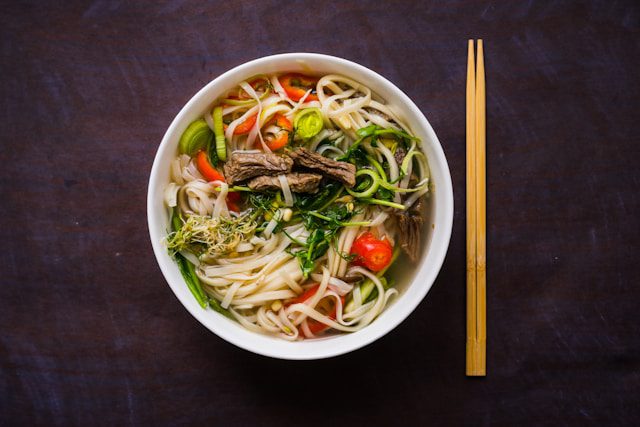 A comforting bowl of rich broth, tender noodles, and fresh herbs