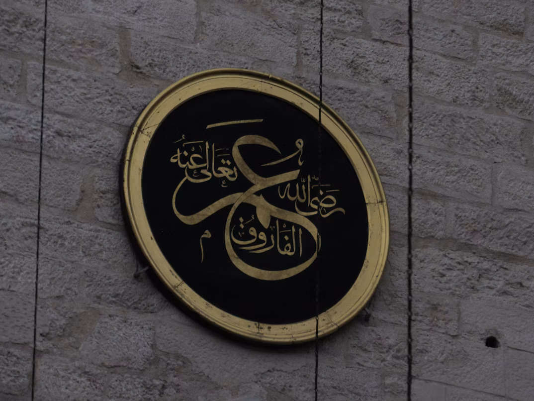 Framed Arabic calligraphy artworks displayed in a gallery