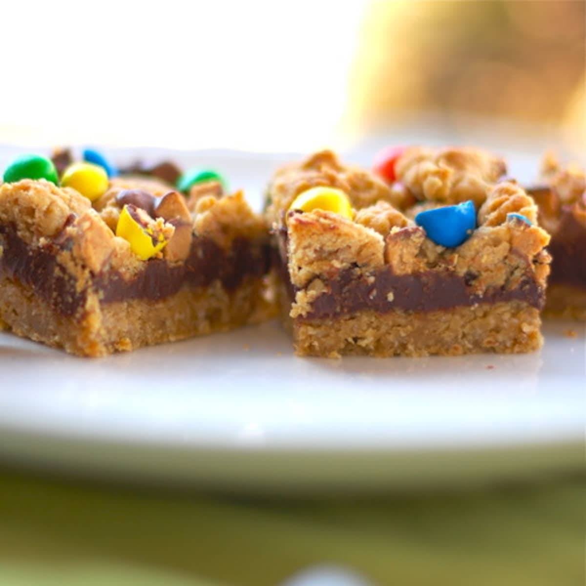 Candy fudge bars with colorful candy topping on a white plate.