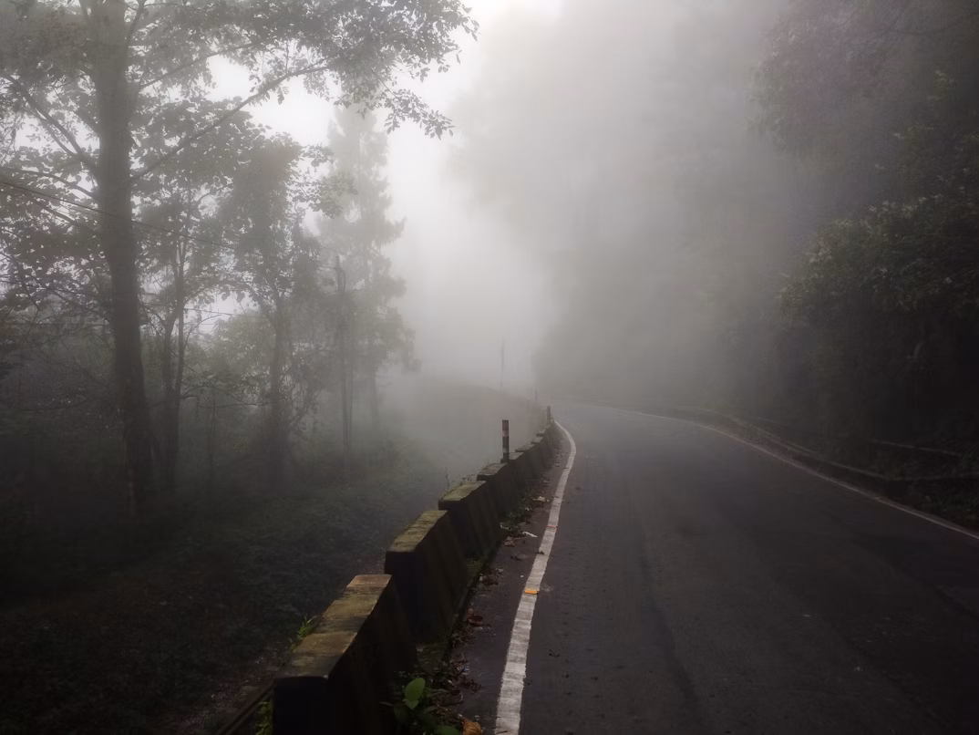 Road cutting through green hills in Nepal