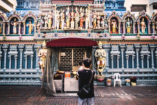 Tourist photographing ornate Hindu temple