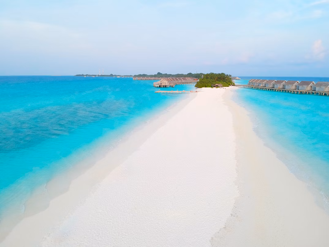 Calm turquoise waters and an empty beach in the Maldives during the shoulder season